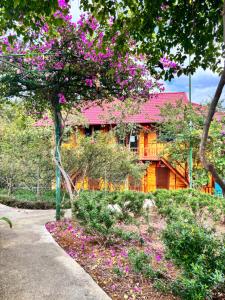 a house with pink flowers in front of it at Than Uyên hotel in Than Uyên