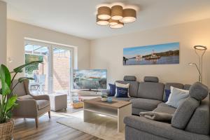 a living room with a couch and a table at Kanalkajüte Theodor in Hanerau-Hademarschen +42 photos