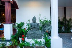 a statue in front of a building with flowers at Villa Elixir Fort Kochi in Cochin