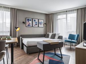 a hotel room with a bed and a couch at Aparthotel Adagio Paris Suresnes Longchamp in Suresnes