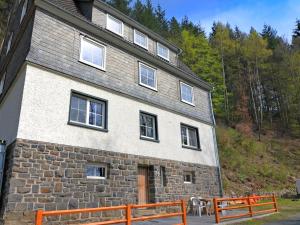 a stone building with two benches in front of it at Villa with Sauna in Liesen in Hallenberg