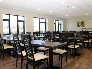 a dining room with tables and chairs and windows at Sunset Quarters at Marine Court in Littlehampton