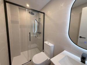 a bathroom with a shower and a toilet and a sink at NEW - Old Town Modern Apartment Close to Beach in Estepona +5 photos