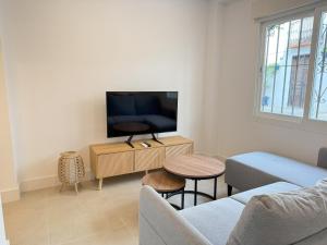 a living room with a couch and a tv at NEW - Old Town Modern Apartment Close to Beach in Estepona