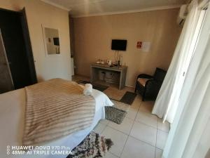 a bedroom with a bed and a table with a chair at Akkerdam Bed and Breakfast in Calvinia