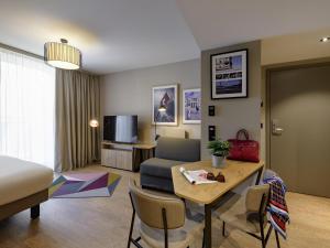 a living room with a bed and a table with chairs at Aparthotel Adagio Zurich City Center in Zürich +159 photos
