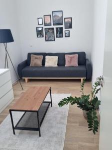 a living room with a blue couch and a coffee table at L8 Street - Mönsheim in Mönsheim