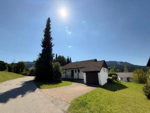 a house with a tree on the side of a road at Landhaus Margarete im Feriendorf Reichenbach in Nesselwang
