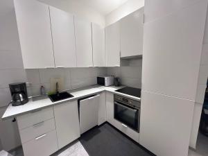 a white kitchen with white cabinets and appliances at L8 Street - Mönsheim in Mönsheim