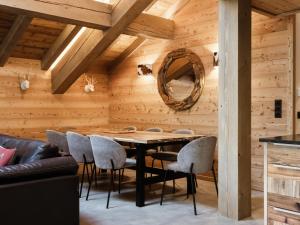 ein Esszimmer mit Holzwänden sowie einem Tisch und Stühlen in der Unterkunft Duplex 4★, 8 pers, cheminée, proche pistes - FR-1-304-295 in La Clusaz + 8 Fotos