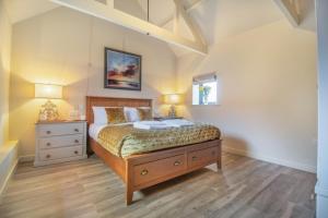 a bedroom with a bed and a dresser and two lamps at White House Lodges - Tawny in Heveningham