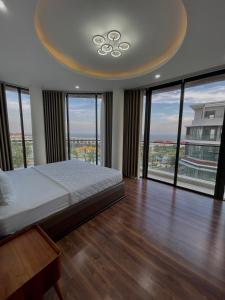 a bedroom with a bed and floor to ceiling windows at SONA Hotel - Muine, Phan Thiet, Summerland in Ấp Chợ Dinh