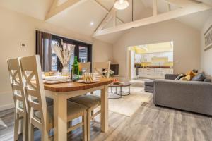 a dining room and living room with a table and chairs at White House Lodges - Tawny in Heveningham
