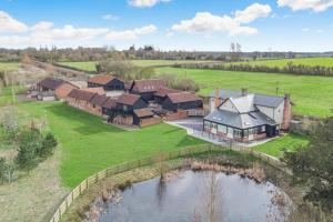 an aerial view of a house with a pond at White House Lodges - Tawny in Heveningham