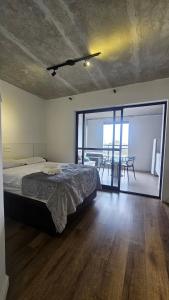 a bedroom with a bed and a balcony with a table at Studio espaço Bom Retiro in Sao Paulo
