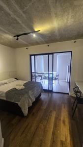 a bedroom with a bed and a balcony with a table at Studio espaço Bom Retiro in Sao Paulo