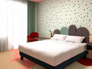 a bedroom with a large white bed and a wall at ibis Styles Bournemouth in Bournemouth