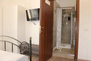 a bedroom with a bed and a shower with a television at Rooms Piramide in Rome +26 photos
