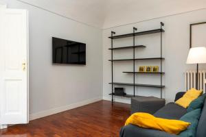 a living room with a couch and a tv on a wall at Casa Vero Amore in Turin