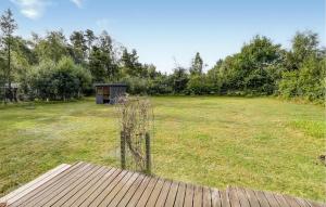 a field with a dog house in the middle of it at 3 Bedroom Stunning Home In Rødby in Bjergemark