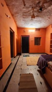 Habitación vacía con paredes de color naranja y techo. en Tom's place hampi, en Hampi