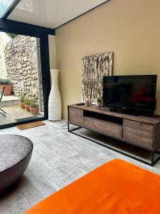 ein Wohnzimmer mit einem Flachbildfernseher auf einem Entertainment-Center in der Unterkunft Maison cosy pour 2 à Crépy, véranda et jardin in Crépy-en-Valois