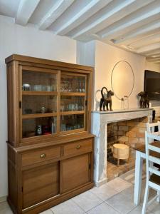 ein großer Holzschrank in einem Zimmer mit Kamin in der Unterkunft Maison cosy pour 2 à Crépy, véranda et jardin in Crépy-en-Valois