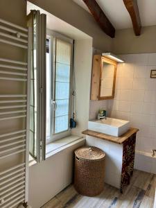 ein Badezimmer mit Waschbecken und Fenster in der Unterkunft Maison cosy pour 2 à Crépy, véranda et jardin in Crépy-en-Valois