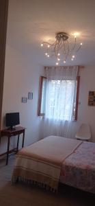a bedroom with a bed and a window and a chandelier at Teatro degli Etruschi in Perugia