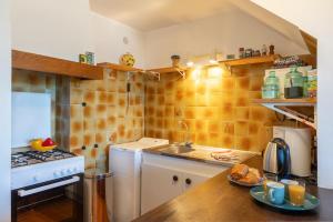 Una pequeña cocina con fregadero y estufa. en Casa Olivia, en Saint-Florent