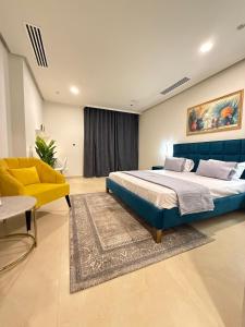 a bedroom with a large bed and a yellow chair at Mall of Islamabad-F7-Luxury Suites in Islamabad