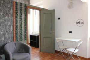 a room with a chair and a table and a door at Rooms Piramide in Rome