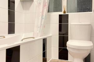 a white bathroom with a toilet and a sink at House - Sleeps 8 - Garden - Parking in Romford +6 photos