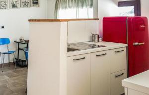 a kitchen with a red refrigerator and a table at Casetta San Giovanni in Giuliana