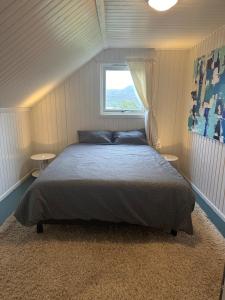 a bedroom with a bed and a window at Cabin with Sauna and Aurora Views in Karlsøy