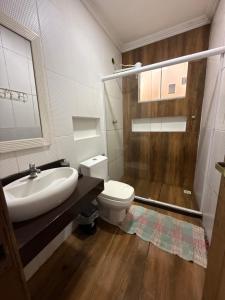 a bathroom with a toilet and a sink and a shower at Kitnet térrea Costa azul in Rio das Ostras