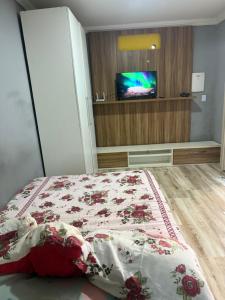a bedroom with a bed with a tv in it at Kitnet térrea Costa azul in Rio das Ostras