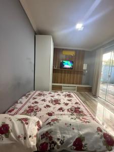 a bedroom with a bed and a tv in it at Kitnet térrea Costa azul in Rio das Ostras