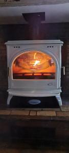 a stove with a fire inside of it at Campagne et bien être - Collection Idylliq in Villiers-sous-Grez +26 photos