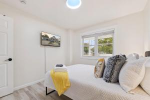a white bedroom with a bed and a window at Pet Friendly, Gated Backyard, Game room, Hot Tub in New Baltimore