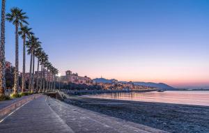 einen Strand mit einer Reihe von Palmen neben dem Wasser in der Unterkunft 2 Bedroom Lovely Apartment In Agropoli in Agropoli