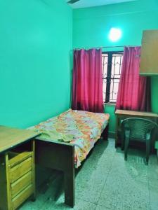 コルカタにあるSubarnarekha Apartment, Bijoygarh, Kolkataのベッドルーム1室(ベッド1台、デスク、デスク付)