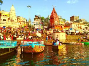 a group of boats in a body of water with buildings at Shree Gomukh residency comfortable home stay for family near to vishwanath temple 200 mtrs in Varanasi