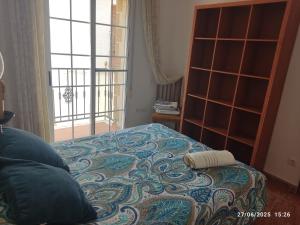 a bedroom with a bed and a book shelf at La casa del abuelo in Ítrabo