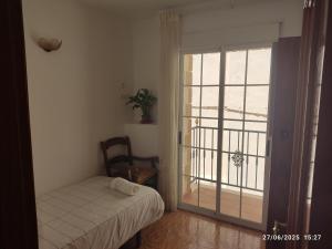 a bedroom with a bed and a sliding glass door at La casa del abuelo in Ítrabo