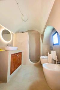 Un baño ovalado con lavabo e inodoro. en Alcova Dora - JACUZZI e TRADIZIONE PUGLIESE nel CUORE di CEGLIE MESSAPICA, en Ceglie Messapica