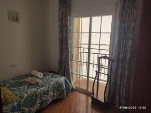 a bedroom with a bed and a large window at La casa del abuelo in Ítrabo +2 photos