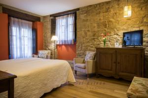 a hotel room with a bed and a tv at El Peiron in Sos del Rey Católico