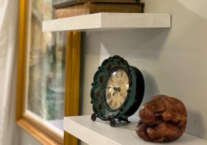 a clock sitting on a shelf next to a rock at Venetian Beds, Outdoor Barrel Sauna, Hot tub, Cold Plunge in Charlotte