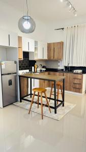 a kitchen with a table and two chairs and a refrigerator at Ikamba-Lakeview Apartment in Kampala